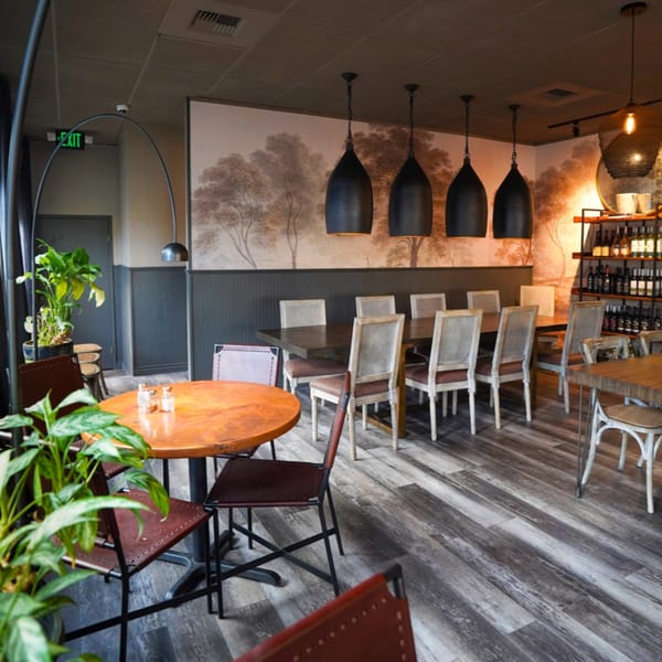 Interior of Olympia Pizza & Spaghetti House II, featuring dining tables, chairs, and decorative lighting.
